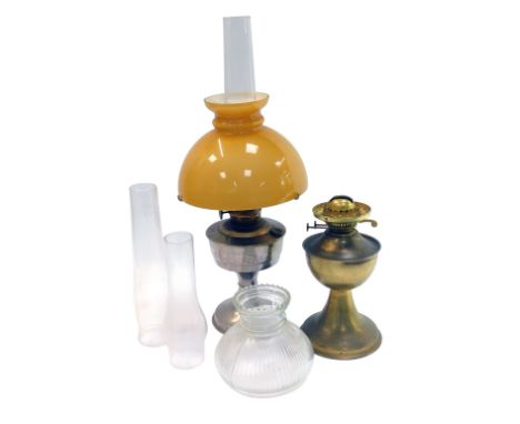 A 20thC oil lamp, with yellow glass shade above a chrome base, with chimney, 60cm high, together with a further brass oil lam