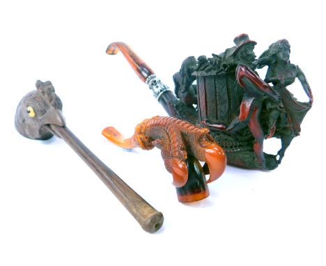 A meerschaum pipe modelled as a claw holding a tobacco bowl, with amber cheroot, 12cm long, together with a Continental carve