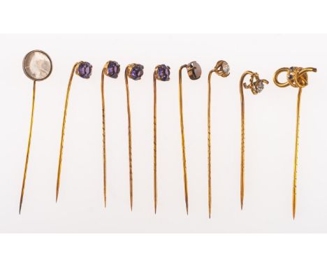 A collection of nine antique gilt stick pins, including four with matching purple paste stones and four other paste stone set