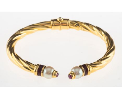 Brev.  An enamel, pearl and ruby bangle, a twisted design hinged torque bangle set to each end with a band of red enamelling,