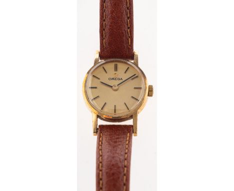 Omega. A vintage 9ct gold cased wristwatch, a mechanical wind, circular faced wristwatch with a signed gold tone dial, black 