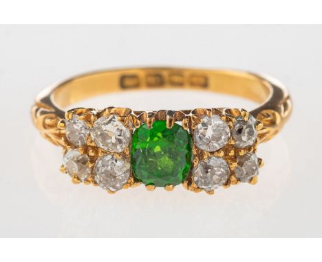 An early 20th century 18ct gold ring, claw set to the centre with an oval-cut green stone, (possibly Tsavorite garnet?), set 