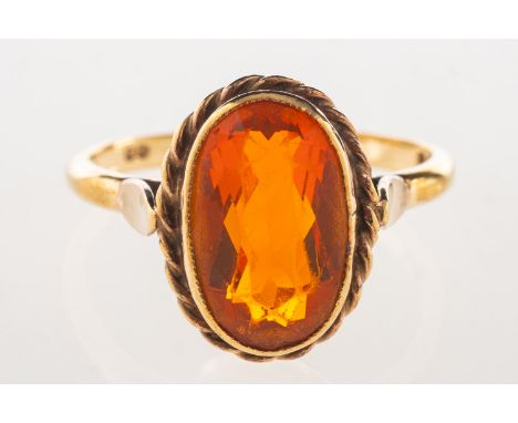 A 9ct gold ring, bezel and rope twist set with an oval-cut orange stone, UK hallmark, size Q1/2, 3.4grams.(Note: unable to co