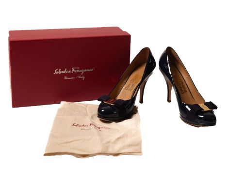 Salvatore Ferragamo. A pair of Tina pumps, in the patent colour 'Oxford Blu', with a navy blue bow and gold tag to the toe, s