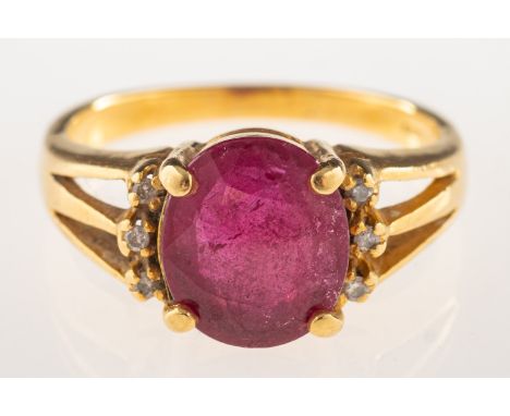 An 18ct gold ruby and diamond ring, set with an oval-cut ruby and three small brilliant-cut diamonds set each side, UK hallma
