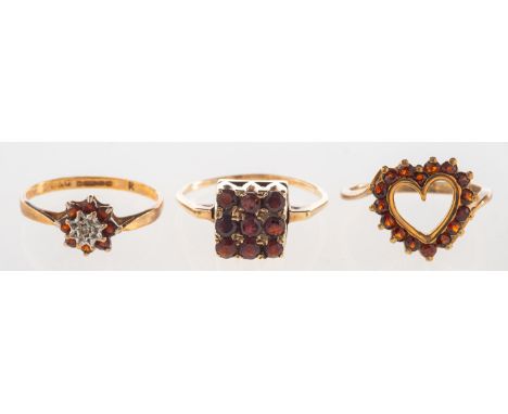 A group of three garnet set rings, including a 9ct gold openwork heart shaped ring set with circular-cut garnets, UK hallmark