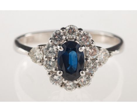 A sapphire and diamond cluster ring, set to the centre with an oval-cut sapphire and a surround of brilliant-cut diamonds, di