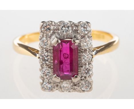 An 18ct gold ruby and diamond cluster ring, of rectangular form and claw set to the centre with a rectangular-cut ruby, ruby 