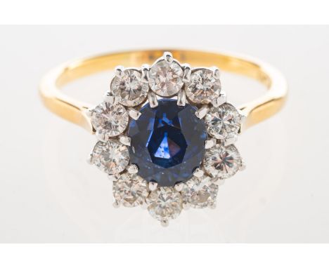 A sapphire and diamond cluster ring, set to the centre with an inky blue oval-cut sapphire, sapphire approx. 1.96 carats, wit