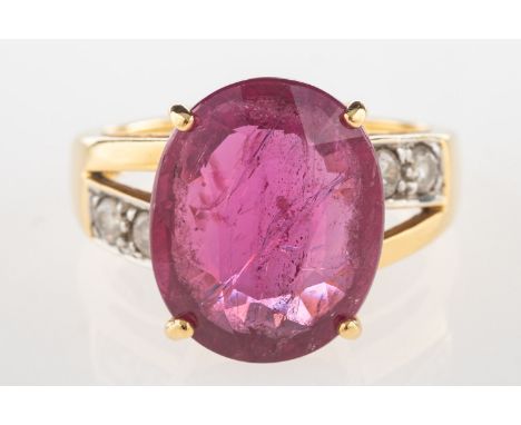 An 18ct gold ruby and diamond ring, claw set with an oval-cut ruby, ruby approx. 5.35 carats, with two brilliant-cut diamonds