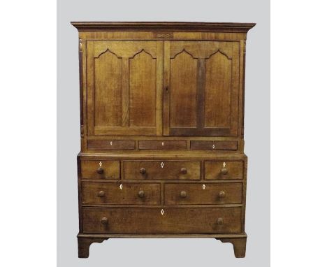 A 19th century oak livery cupboard, possibly mid Wales, the cavetto cornice over two twin ogee arched panel cabinet doors ope