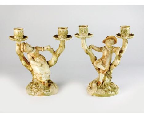 A pair of James Hadley for Royal Worcester blush ivory figural candelabra, late 19th century, featuring boy and girl resting 