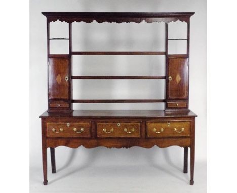 A George III oak crossbanded mahogany Shropshire type dresser, the rack with wavy cornice over three central open shelves fla