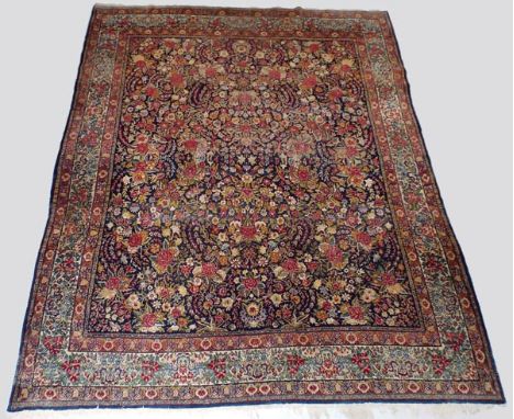 A 20th century North West/Central Persian blue and red ground carpet, the centre overall decorated with scrolling leaves and 