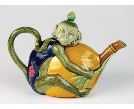 A Minton majolica teapot and cover, shape number 1844, year cypher for 1886, , the costumed ape clasping a large fruit, his h
