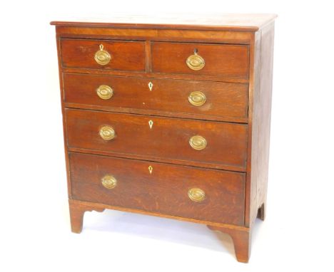 An early 19thC oak and mahogany chest of drawers, the top with a moulded edge above two short and three long drawers, each wi