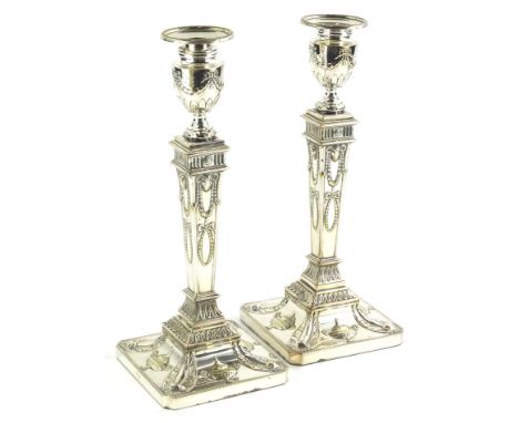 A pair of silver plated candlesticks, modelled in neo classical style, in the manner of Robert Adam, with swags, rams heads, 