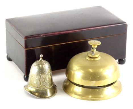 A brass porter's bell, of circular form, with central button, 9cm high, ER helmet bell and a musical cigarette case, of recta