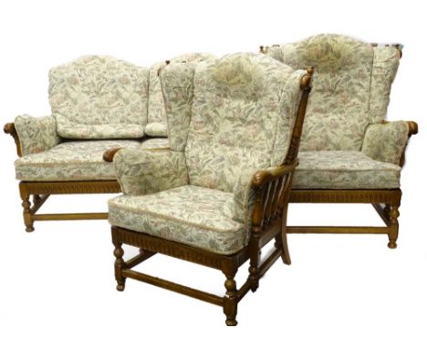 An Ercol light elm cottage type suite, the two seat sofa with shaped arms and fluted frieze, on part turned legs and bun feet