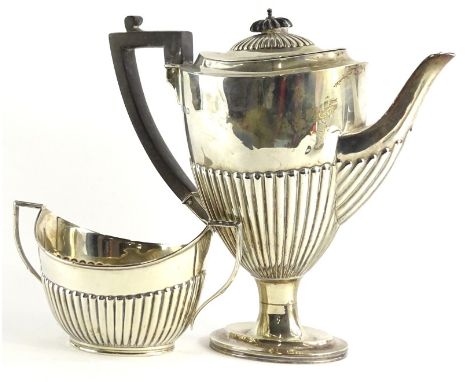 A George V silver urn shaped coffee pot, with part fluted decoration, ebonised knop and handle, on a domed foot, and a matchi