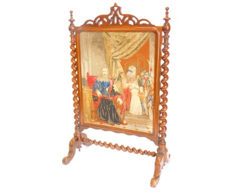 A Victorian rosewood firescreen, with a pierced crest above a wool work panel depicting King Charles etc., flanked by spirall