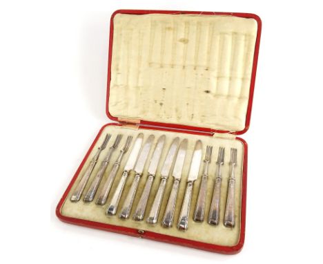 A set of six George V silver handled dessert knives and forks, with silver plated blades, Sheffield 1917, in red simulated le