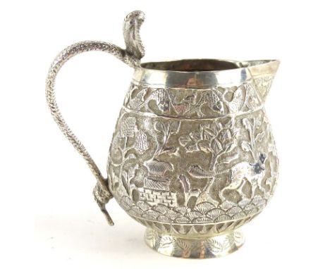 An eastern silver cream jug, with repousse decoration of elephants, palm trees, buildings, etc., possibly Indian, 2¾oz, 9cm h