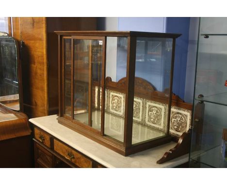 An oak table top shop display cabinet with glass shelf and sliding doors, 81cm wide