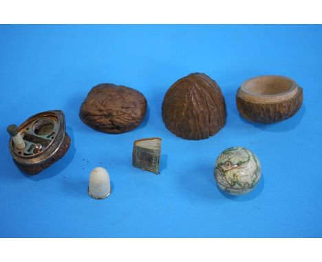 A Black forest style carved walnut containing a small terrestrial globe and a walnut shell with gold coloured mounts, opening