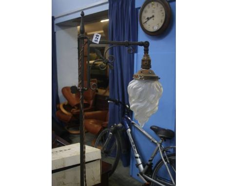 A Liberty style wrought iron standard lamp with white frosted shade