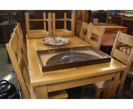 A Barker and Stonehouse light oak dinning table with extensions to each end and having eight single chairs, 272cm length and 