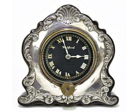 JOSEPH GLOSTER; a George VI hallmarked silver mounted mantel clock of shaped form, the dial signed Watford, silver marks for 