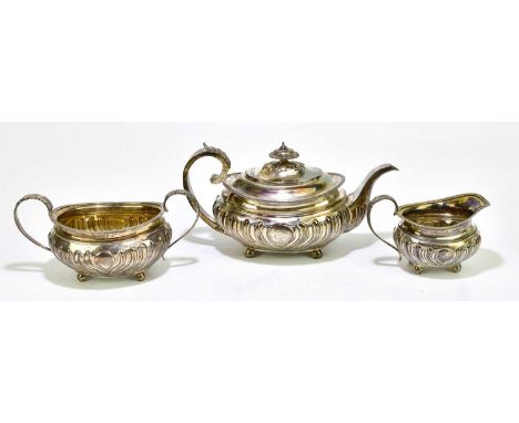 SARAH & JOHN WILLIAM BLAKE; a George III hallmarked silver three piece tea service of oval form with repoussé decoration surr