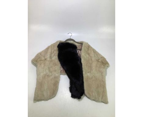 A light cream 1950’s fur stole lined in pink satin, and a black fox fur stole lined with black satin, measures 40”(2)