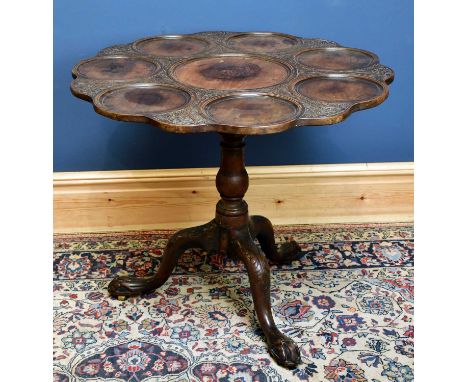 A Georgian carved mahogany supper table, with eight dish rings and bird cage undertier, terminating on ball and claw feet, he
