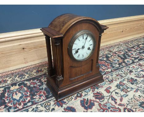 An early 20th century oak mantel clock, with white enamel dial set with Roman numerals, height 33cm.