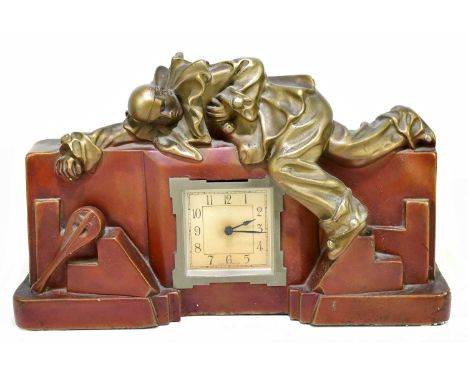 An Art Deco painted plaster mantel clock with shaped rectangular form, relief decorated with a pierrot lying across the clock