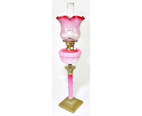 A Victorian oil lamp, with cranberry and clear glass shade with wavy rim above etched floral decoration, above the moulded cr