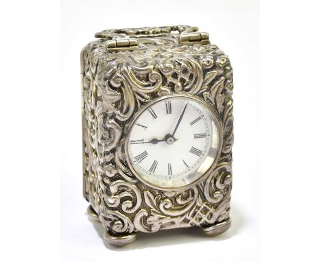 HENRY MATTHEWS; a Edward VII hallmarked silver cased travelling clock, with foliate decoration, with white enamelled dial set