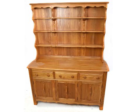 ERCOL; a light elm dresser with plate rack back, with three fixed shelves above an arrangement of three drawers and three pan