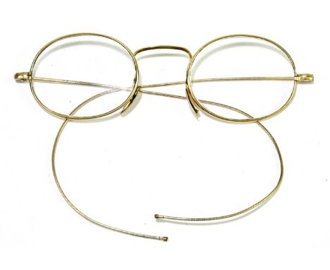 A pair of vintage yellow metal framed spectacles in case.