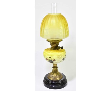 A Victorian oil lamp, the yellow glass shade with etched decoration depicting butterlies and floral sprays above the yellow m