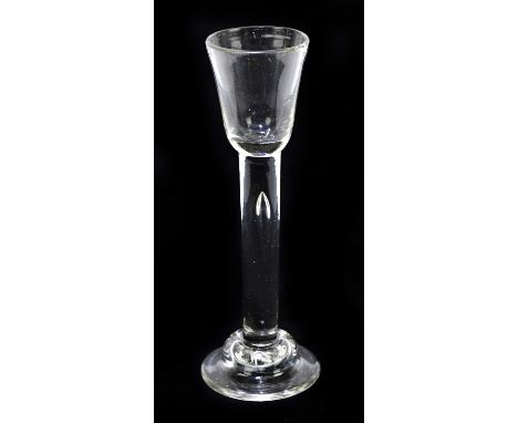 An 18th century Irish wine glass, the bell shaped bowl raised on a clear stem with tear drop inclusion on a stepped foot, hei