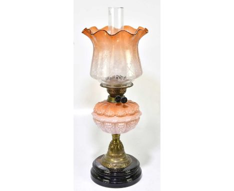 A Victorian oil lamp, the orange and clear glass shade with wavy rim having etched decoration with the orange and pink glass 