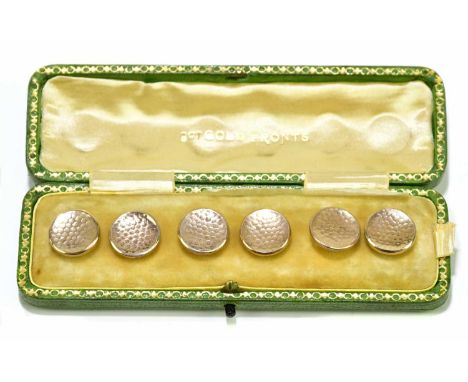 A cased set of six mother of pearl backed and rose gold dimpled shirt studs with button loop attachments beneath the velvet p