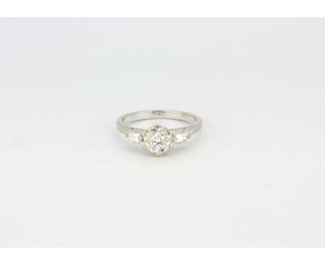 A 18ct white gold hallmarked ring set with a centre brilliant cut diamond (approx. 0.25ct) with baguette cut diamond set shou