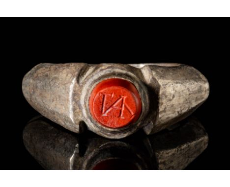 Ca. AD 200 - 400.A late Roman silver ring. It has a round band, shoulders with flat panels and a red jasper intaglio decorate
