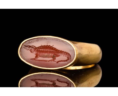 Ptolemaic, Ca. 300 - 100 BC.A gold finger ring of Henig type I, with a round hoop and an elongated bezel setting enclosing ca