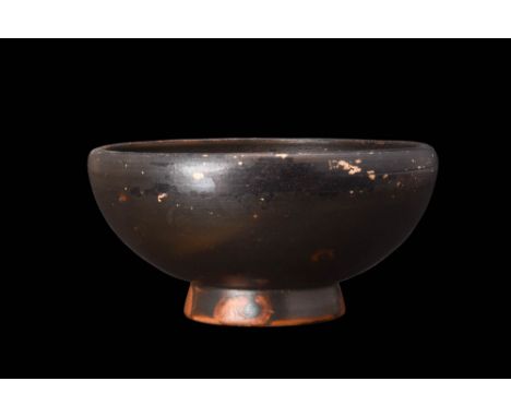 Ca. 350 BC.An attractive salt cellar or small bowl with its warm, brownish glaze. The bowl's hemispherical basin features an 