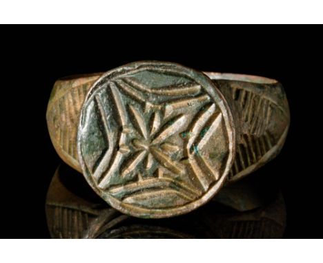 Ca. AD 1000 - 1300.A bronze ring with a circular band and a large bezel decorated with the star of Bethlehem. This is a recur
